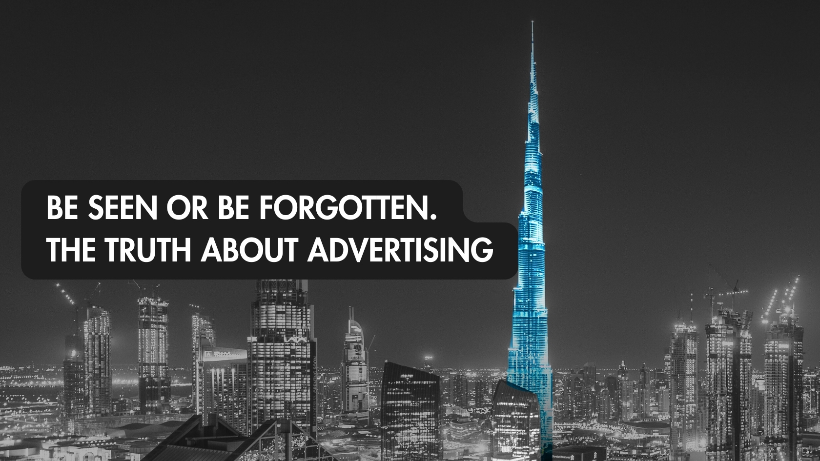 Single illuminated skyscraper standing out in a dark city skyline at night showing the power of visibility in business.